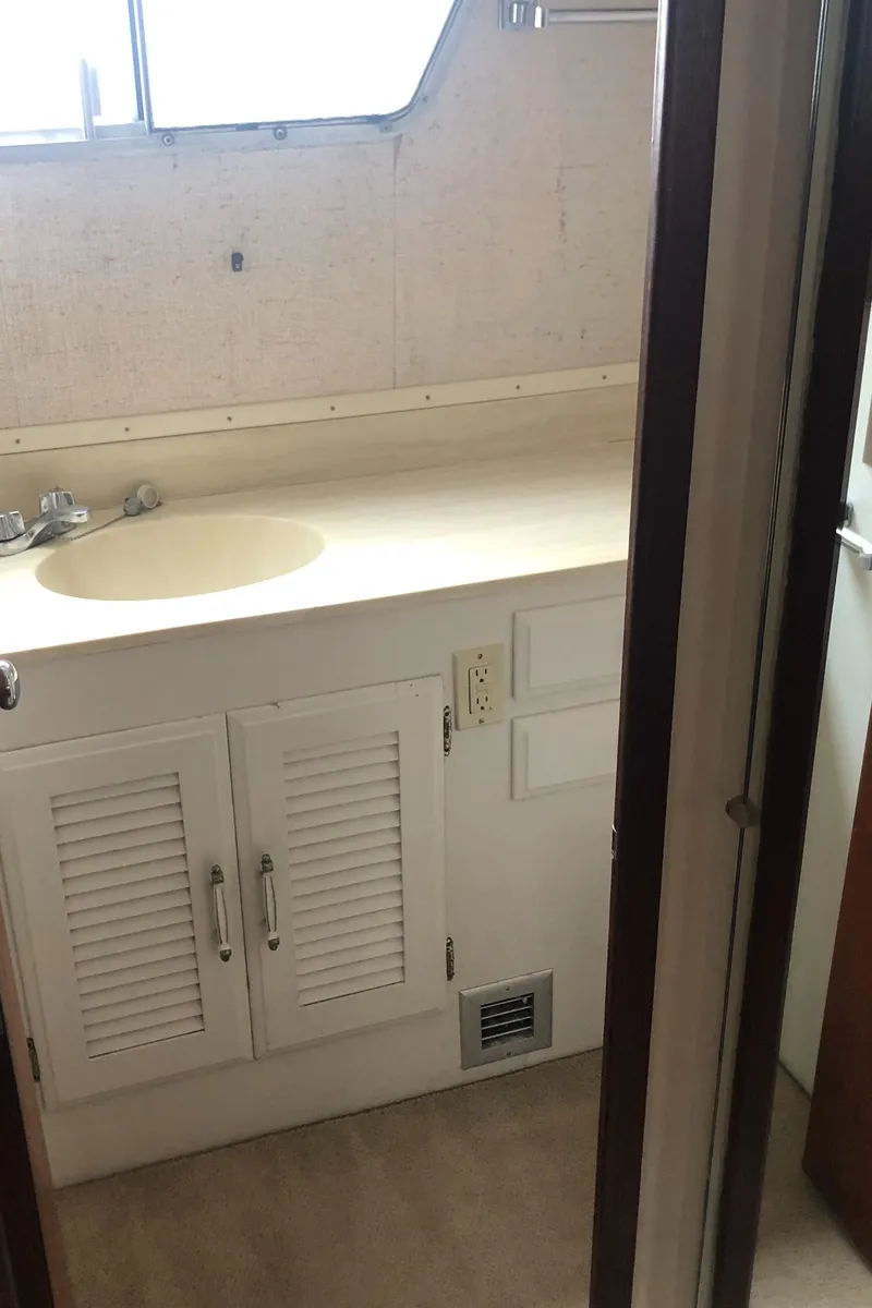 Slide: The Image of 1976 Tollycraft 48 Cockpit Motor Yacht bathroom with sink and storage cabinets. - 27