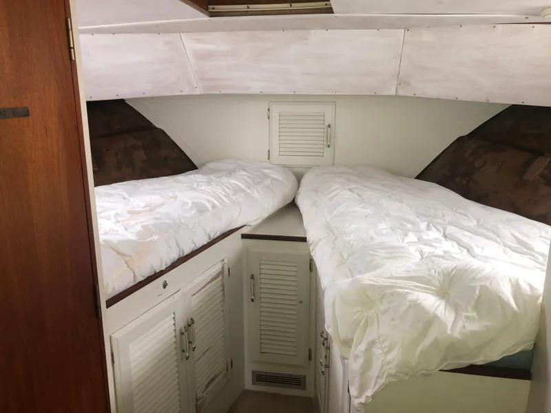 Slide: The Image of 1976 Tollycraft 48 Cockpit Motor Yacht cabin with twin beds and white bedding. - 29