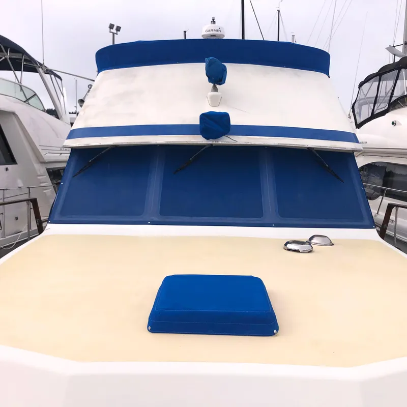 Slide: The Image of 1976 Tollycraft 48 Cockpit Motor Yacht with blue accents, docked at a marina. - 3