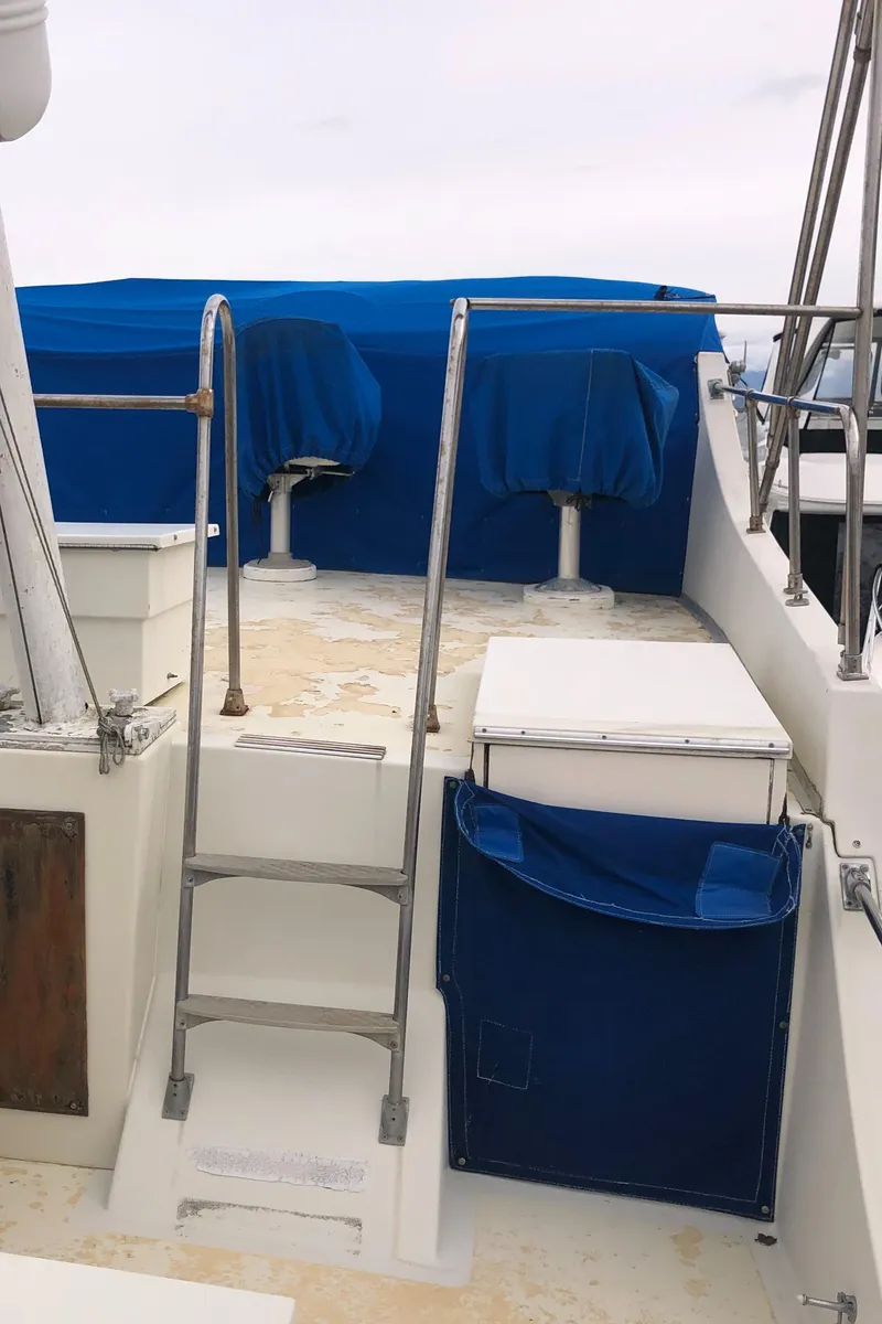 Slide: The Image of 1976 Tollycraft 48 Cockpit Motor Yacht deck with blue-covered seating and ladder. - 6