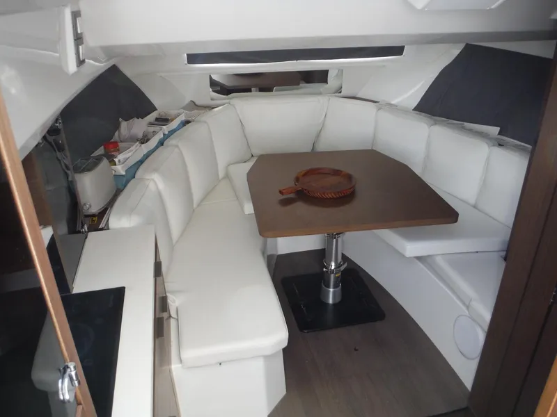 Slide: The Image of 2023 Jeanneau Leader 10.5 WA Series 2 interior with white seating and wooden table. - 28