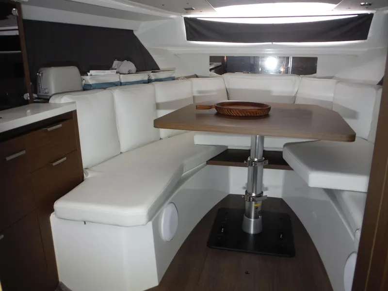 Slide: The Image of 2023 Jeanneau Leader 10.5 WA Series 2 interior with white seating and wooden table. - 31