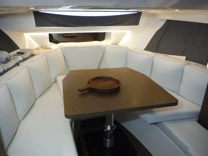 Slide: The Image of 2023 Jeanneau Leader 10.5 WA Series 2 cabin with white seating and wooden table. - 35