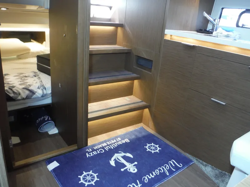 Slide: The Image of Interior of 2023 Jeanneau Leader 10.5 WA Series 2, featuring wooden stairs and cozy cabin. - 37