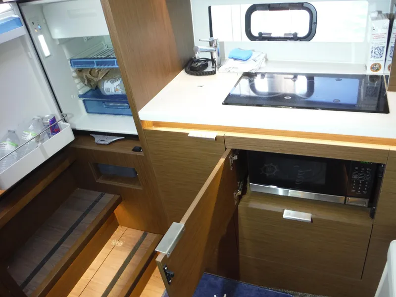 Slide: The Image of 2023 Jeanneau Leader 10.5 WA Series 2 interior kitchen with fridge, stove, and microwave. - 40