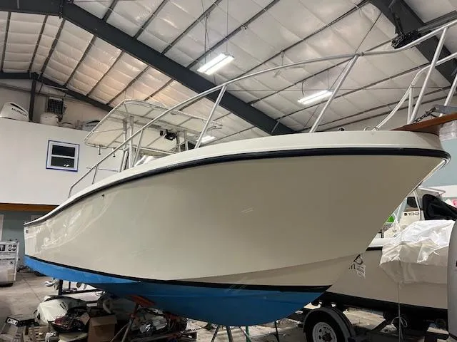 Slide: The Image of 1990 Mako 261 Center Console boat in a storage facility, elevated on a trailer. - 11