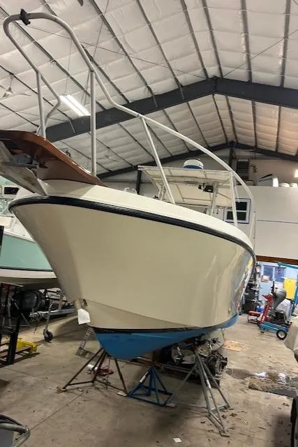 Slide: The Image of 1990 Mako 261 Center Console boat in a workshop setting. - 12