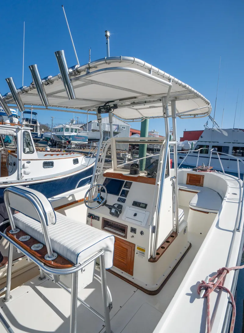 Slide: The Image of 1990 Mako 261 Center Console boat with T-top and fishing rod holders. - 13