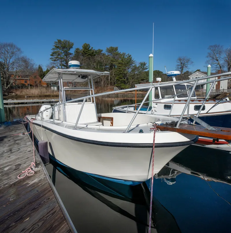 Slide: The Image of 1990 Mako 261 Center Console boat docked at a marina on a sunny day. - 14