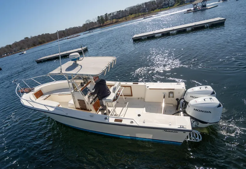 Slide: The Image of 1990 Mako 261 Center Console boat with dual Honda engines on a sunny lake. - 2