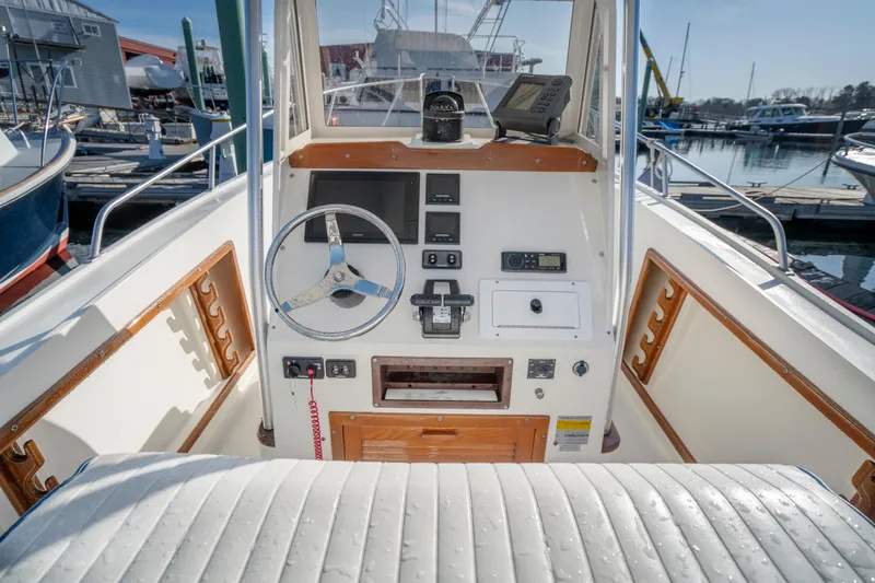Slide: The Image of 1990 Mako 261 Center Console boat interior with steering wheel and control panel. - 3