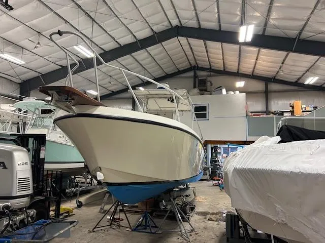 Slide: The Image of 1990 Mako 261 Center Console boat in a spacious indoor storage facility. - 4
