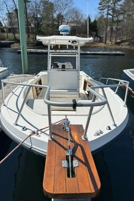 Slide: The Image of 1990 Mako 261 Center Console boat docked on calm water. - 5
