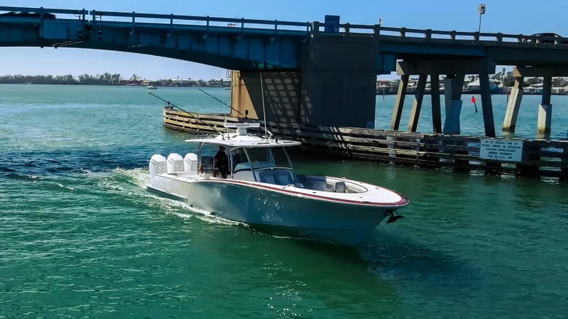 Slide: The Image of 2026 Mag Bay 43 CC boat cruising under a bridge in clear waters. - 1