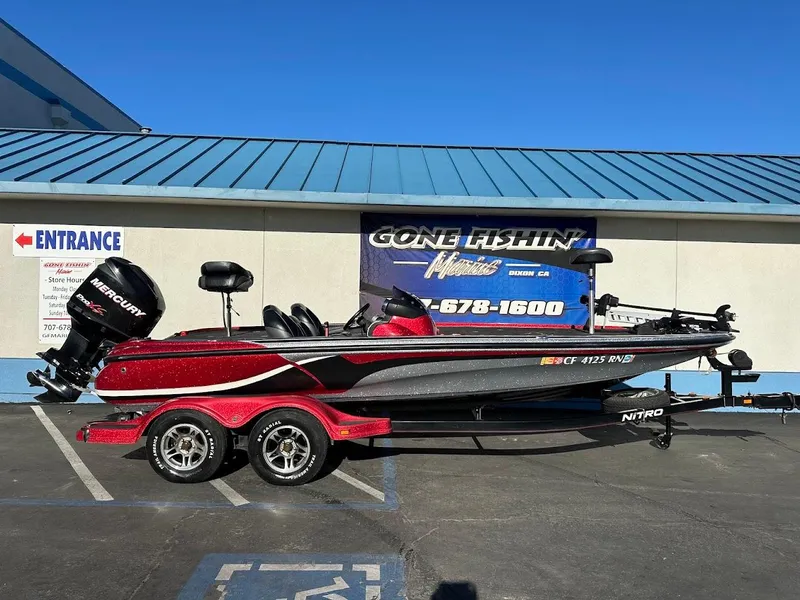 Slide: The Image of 2008 Nitro Z9 boat with Mercury engine on trailer, parked outside a fishing store. - 1