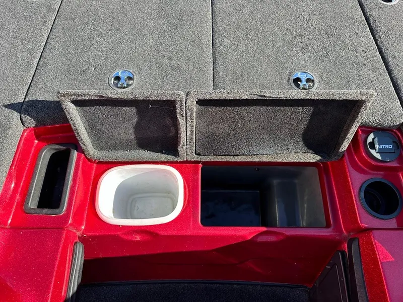 Slide: The Image of 2008 Nitro Z9 boat storage compartments with red trim and carpeted lids. - 28