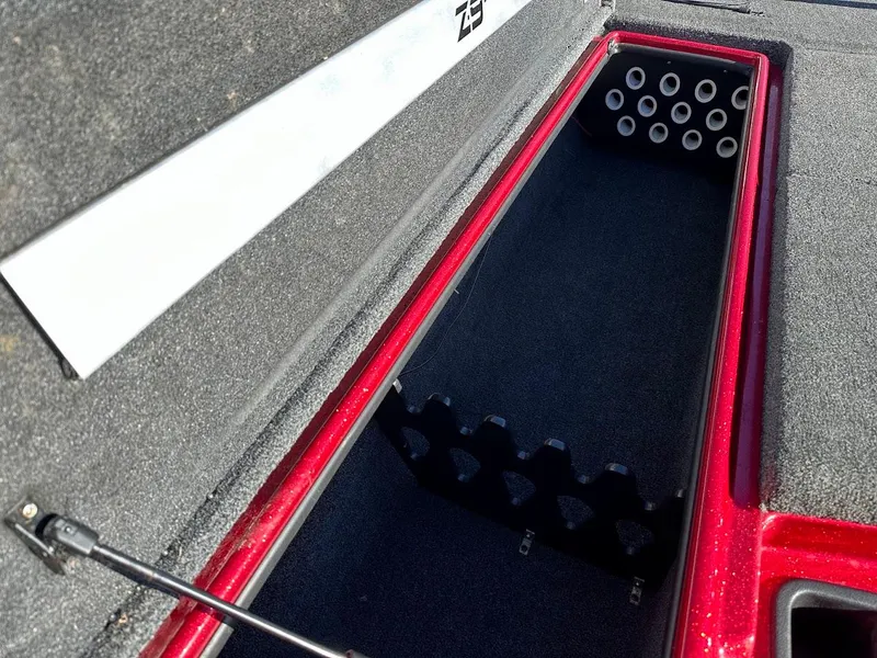 Slide: The Image of Open storage compartment in a 2008 Nitro Z9 boat, featuring rod holders and carpeted interior. - 34