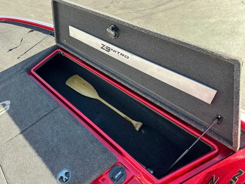 Slide: The Image of Open storage compartment in 2008 Nitro Z9 boat with a wooden paddle inside. - 35