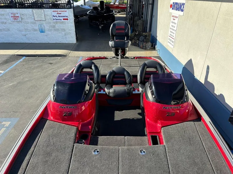 Slide: The Image of Red 2008 Nitro Z9 boat with dual consoles and seating, parked outdoors. - 42