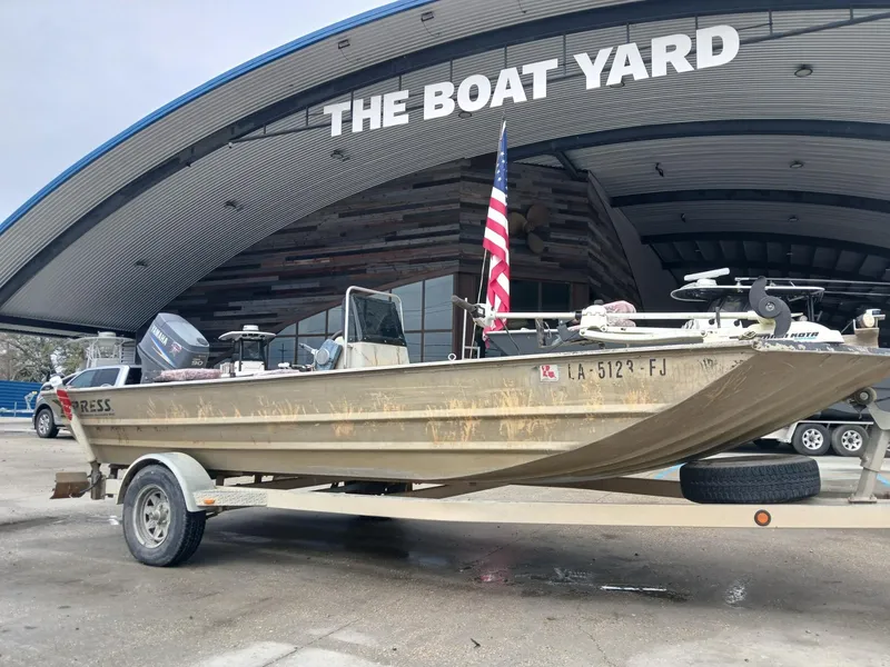 Slide: The Image of 2004 Xpress 18 boat on trailer at The Boat Yard, featuring American flag. - 11