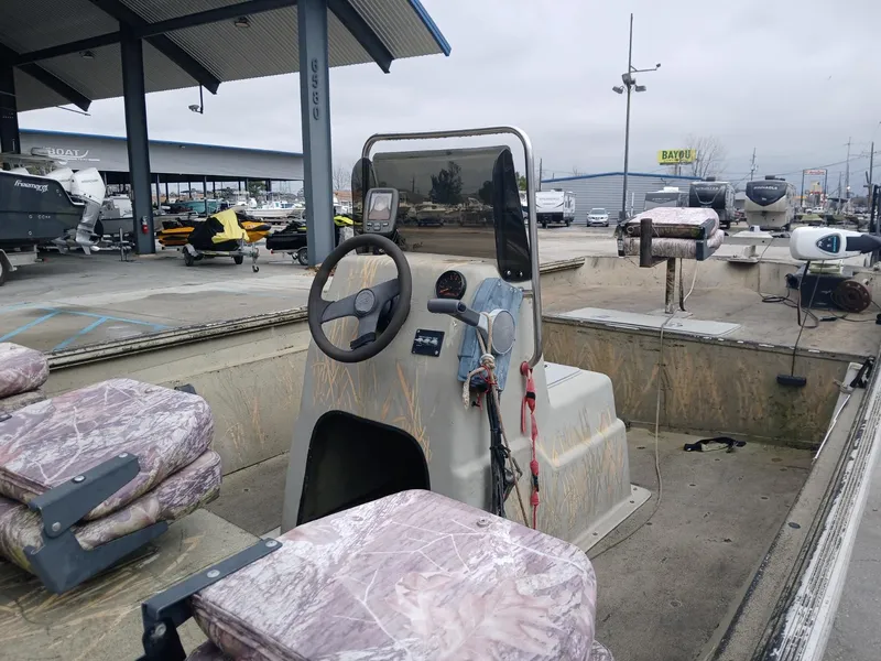 Slide: The Image of 2004 Xpress 18 boat with camouflage seats, steering console, and outdoor showroom setting. - 3