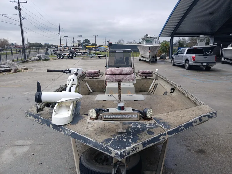 Slide: The Image of 2004 Xpress 18 boat with trolling motor, parked outdoors on a cloudy day. - 6