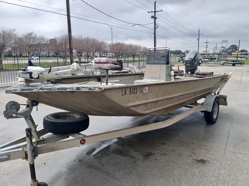 Slide: The Image of 2004 Xpress 18 boat on trailer, parked outdoors on a cloudy day. - 8