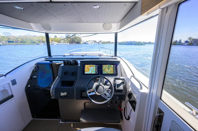 Slide: The Image of 2024 Nimbus C11 boat cockpit with modern navigation system on a serene lake. - 1