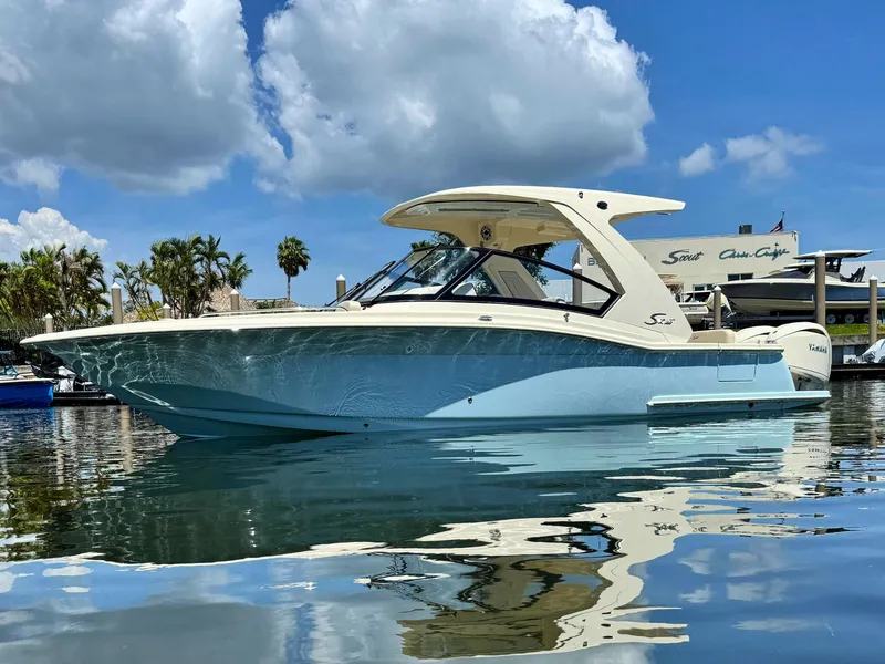 Slide: The Image of 2025 Scout 277 Dorado boat on calm water under a blue sky. - 0