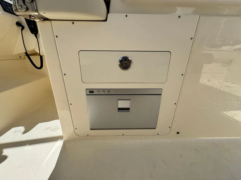 Slide: The Image of 2025 Scout 277 Dorado boat interior with storage compartment and control panel. - 14