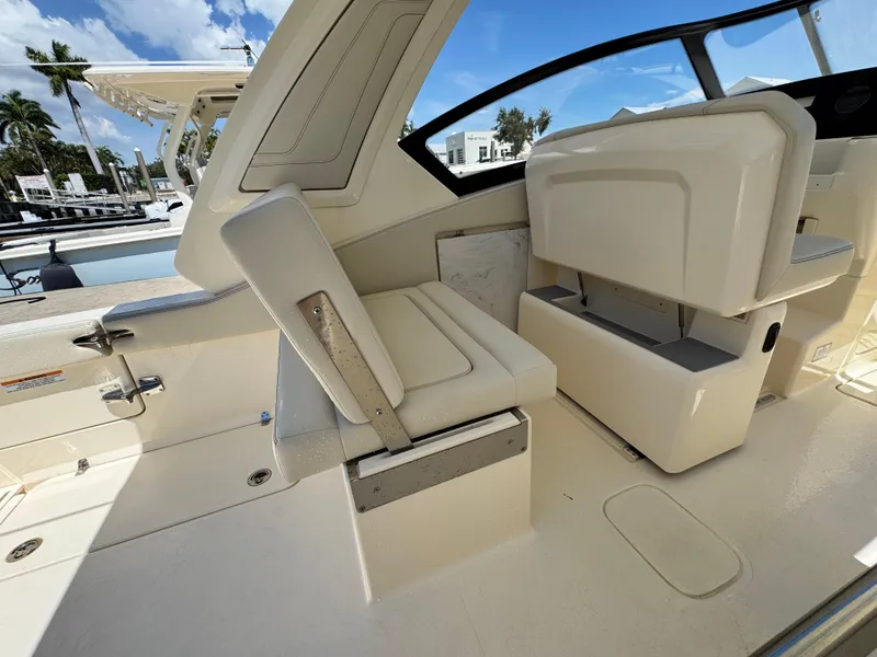 Slide: The Image of 2025 Scout 277 Dorado boat interior with seating and helm, docked under a clear sky. - 16
