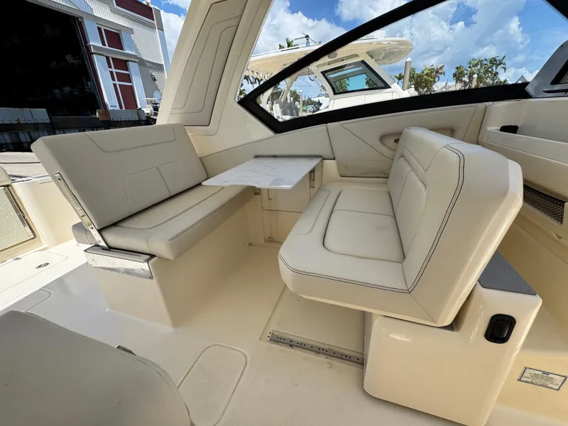 Slide: The Image of 2025 Scout 277 Dorado boat interior with beige seating and table. - 19