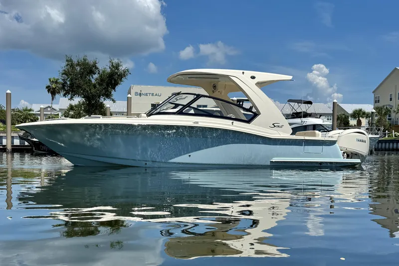 Slide: The Image of 2025 Scout 277 Dorado boat on calm water under a clear blue sky. - 5