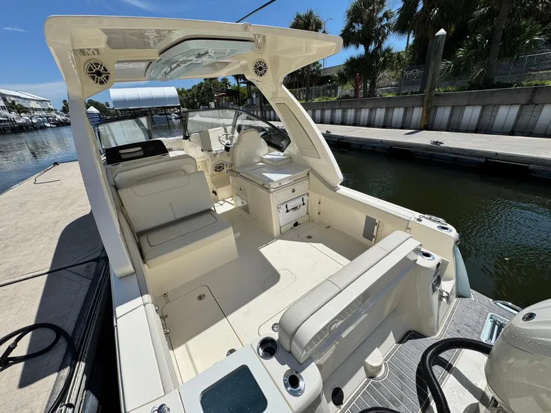 Slide: The Image of 2025 Scout 277 Dorado boat interior at dock, featuring seating and control area. - 6