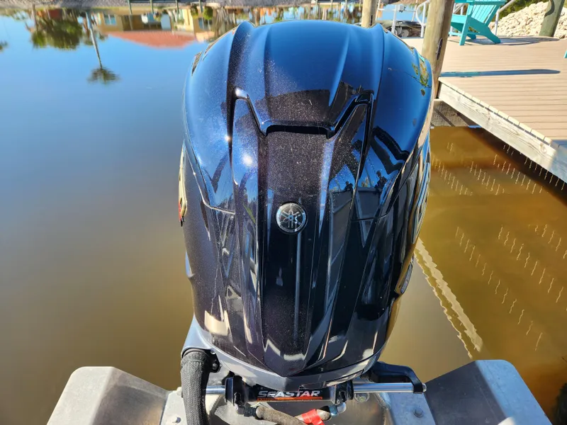 Slide: The Image of 2021 Bennington SX 21 L-Bench boat with Yamaha outboard motor on a calm lake. - 10