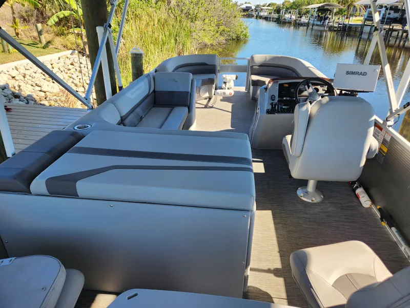 Slide: The Image of 2021 Bennington SX 21 L-Bench pontoon boat interior with gray seating and steering console. - 11