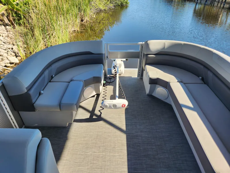 Slide: The Image of 2021 Bennington SX 21 L-Bench pontoon boat interior with spacious seating and scenic water view. - 13