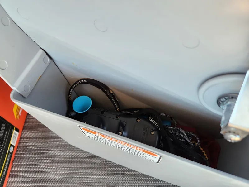 Slide: The Image of Storage compartment in 2021 Bennington SX 21 L-Bench boat with various items inside. - 24