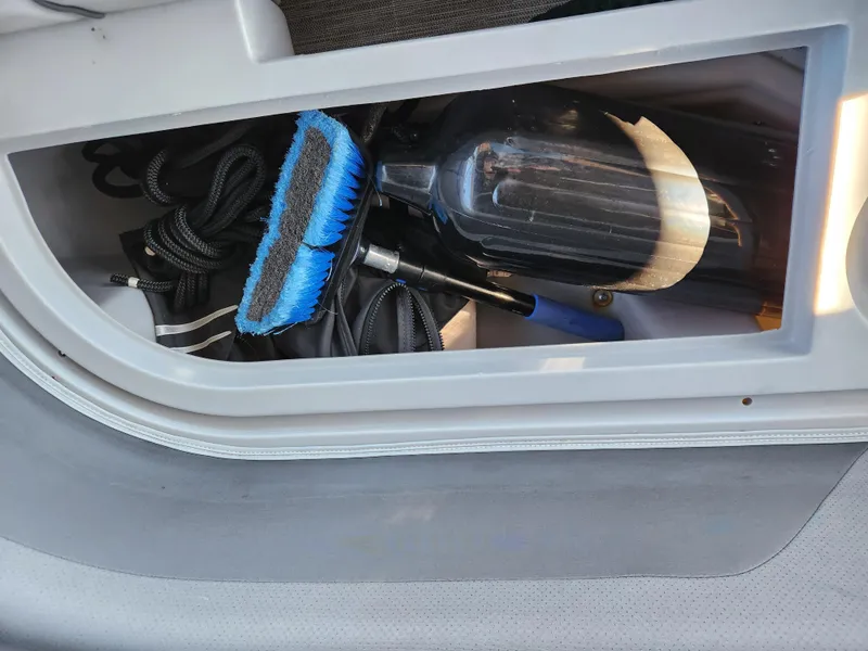 Slide: The Image of Storage compartment in 2021 Bennington SX 21 L-Bench with cleaning tools and ropes. - 26