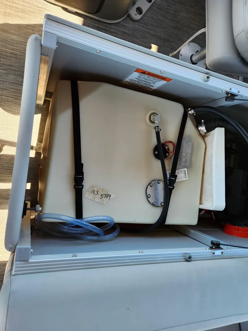 Slide: The Image of 2021 Bennington SX 21 L-Bench storage compartment with secured fuel tank and hoses. - 29