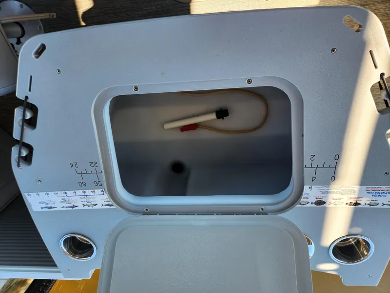 Slide: The Image of 2021 Bennington SX 21 L-Bench storage compartment with measuring guides and cup holders. - 31