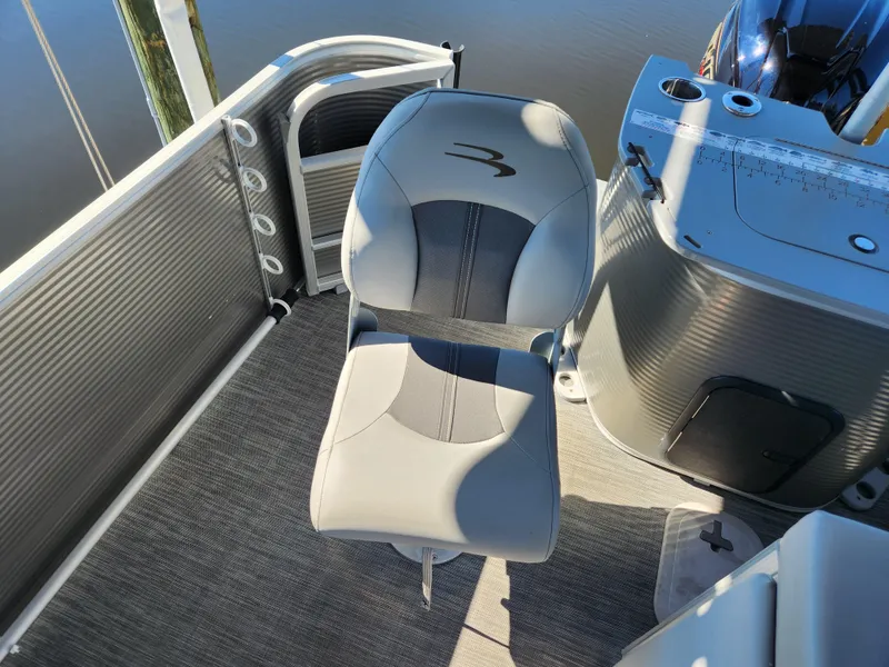 Slide: The Image of 2021 Bennington SX 21 L-Bench boat seat, gray upholstery, near control console, on water. - 33