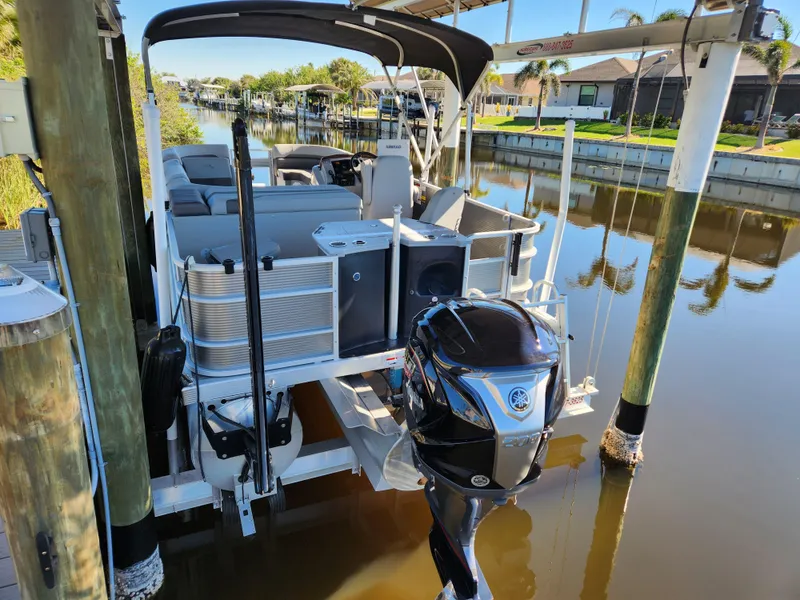 Slide: The Image of 2021 Bennington SX 21 L-Bench pontoon boat docked on a calm canal. - 4