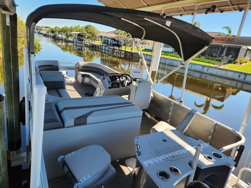 Slide: The Image of 2021 Bennington SX 21 L-Bench pontoon boat with canopy on a calm canal. - 5