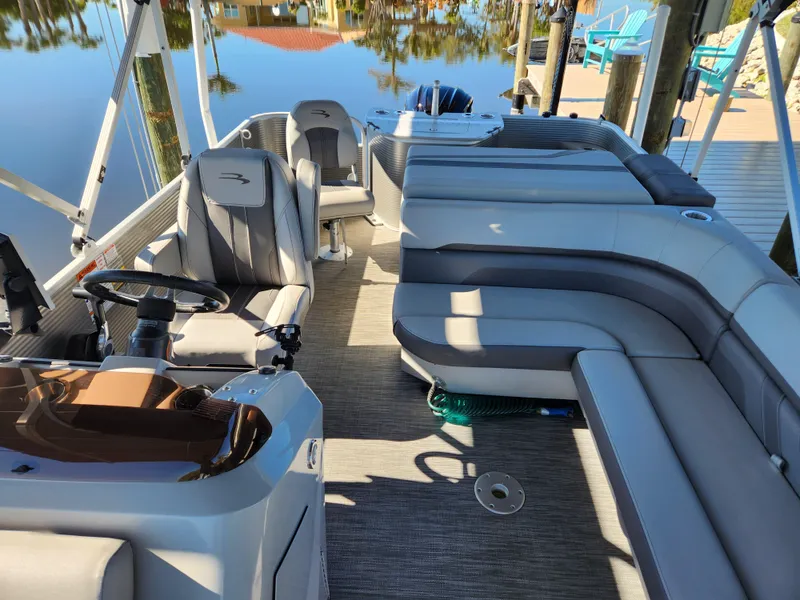 Slide: The Image of 2021 Bennington SX 21 L-Bench pontoon boat interior with plush seating and steering console. - 7