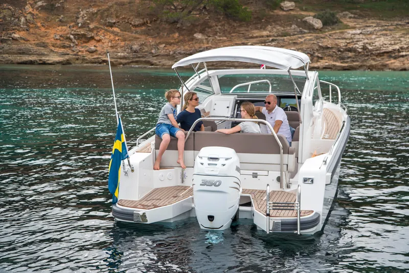Slide: The Image of Family enjoying a day on a 2025 Nimbus Weekender 9 boat in scenic waters. - 5