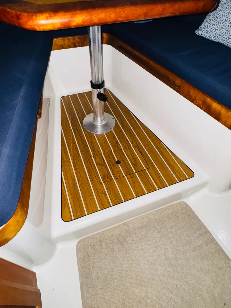 Slide: The Image of 2006 Back Cove Hardtop Express interior with wood flooring and cushioned seating. - 18