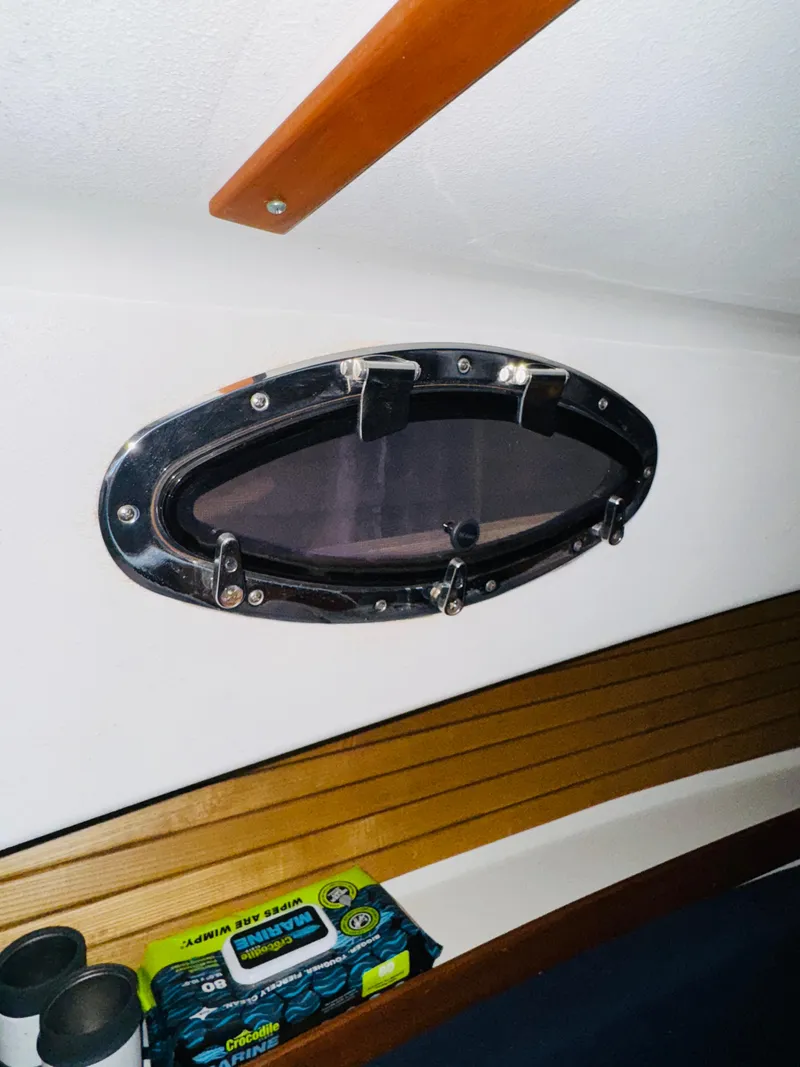 Slide: The Image of 2006 Back Cove Hardtop Express cabin interior with oval porthole and storage shelf. - 20