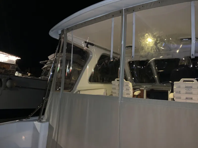 Slide: The Image of 2006 Back Cove Hardtop Express boat at night, featuring enclosed cabin and seating. - 22