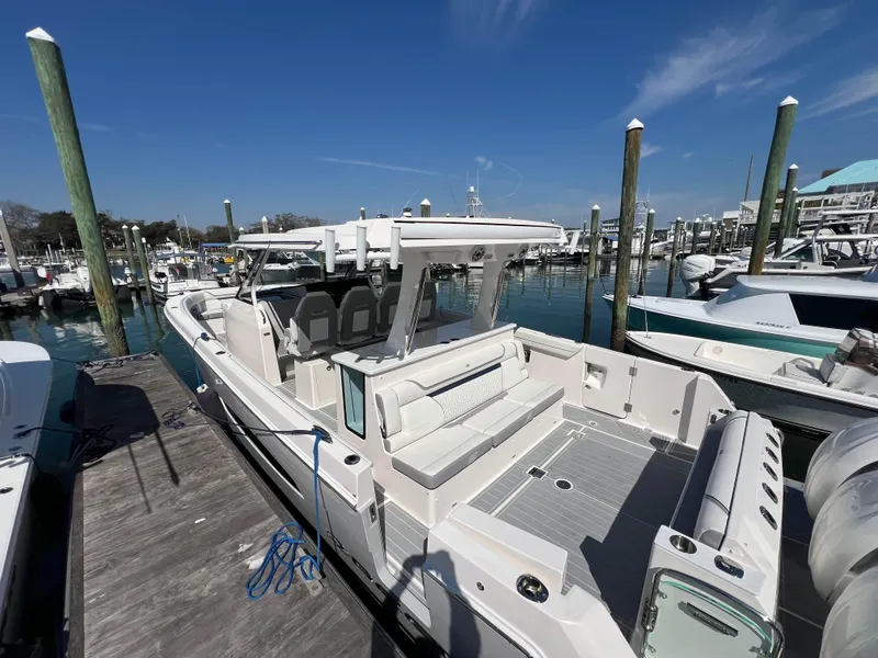 Slide: The Image of 2025 Regal 38 SAV boat cruising on a calm blue waterway. - 1